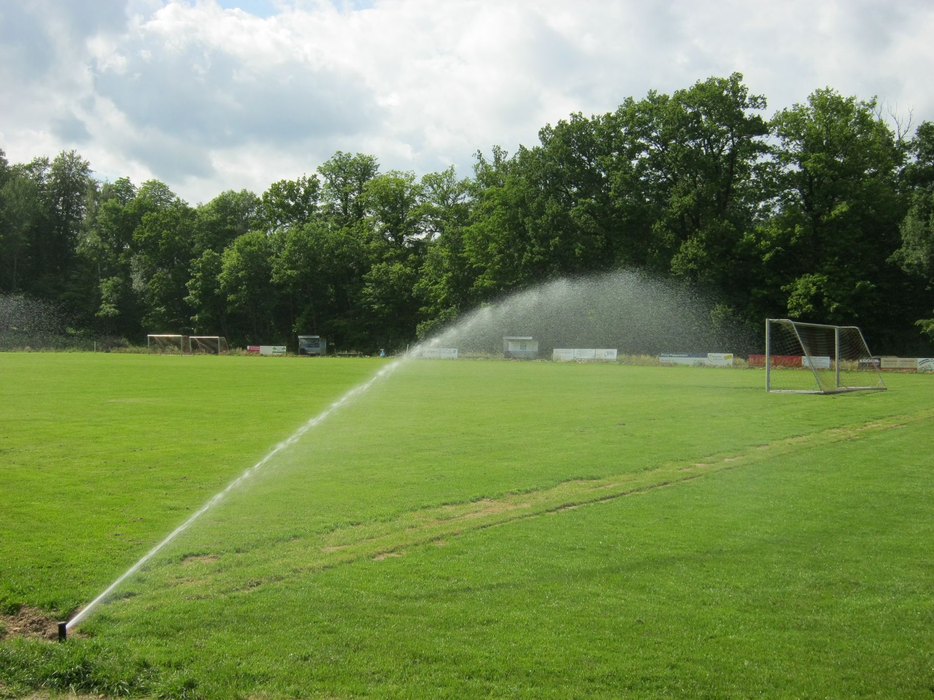 Beregnungsanlagen auf einem Sportplatz mit Naturrasen.