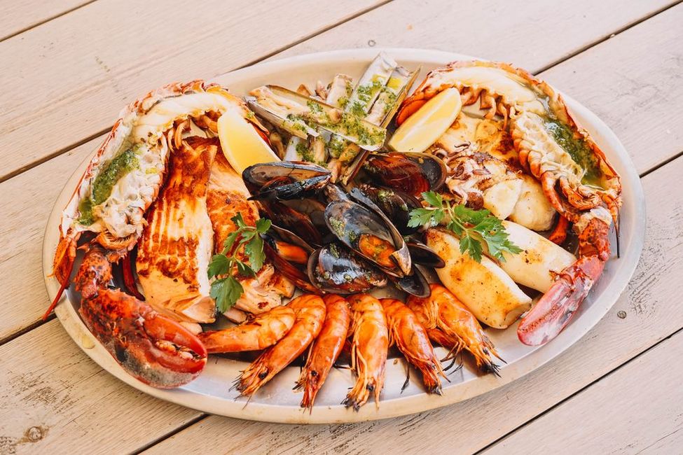 Un plato de mariscos está sobre una mesa de madera.