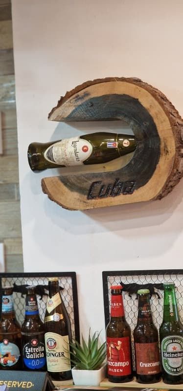 Una botella de cerveza cuelga de un estante de madera.