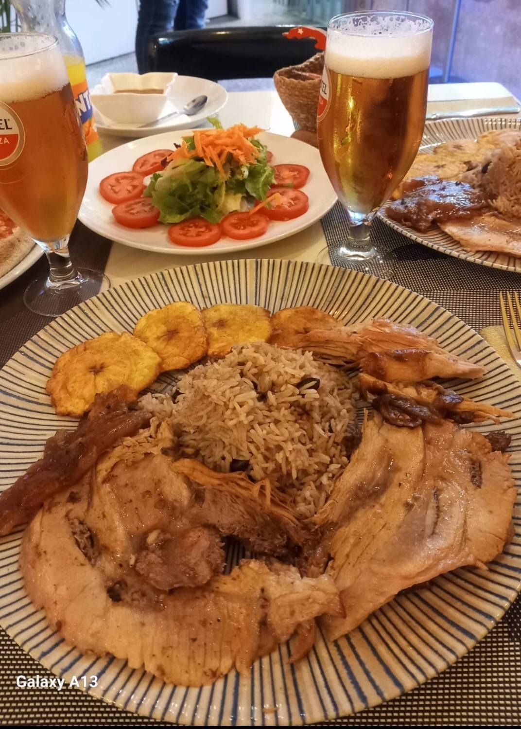 Un plato de comida y dos vasos de cerveza en una mesa.