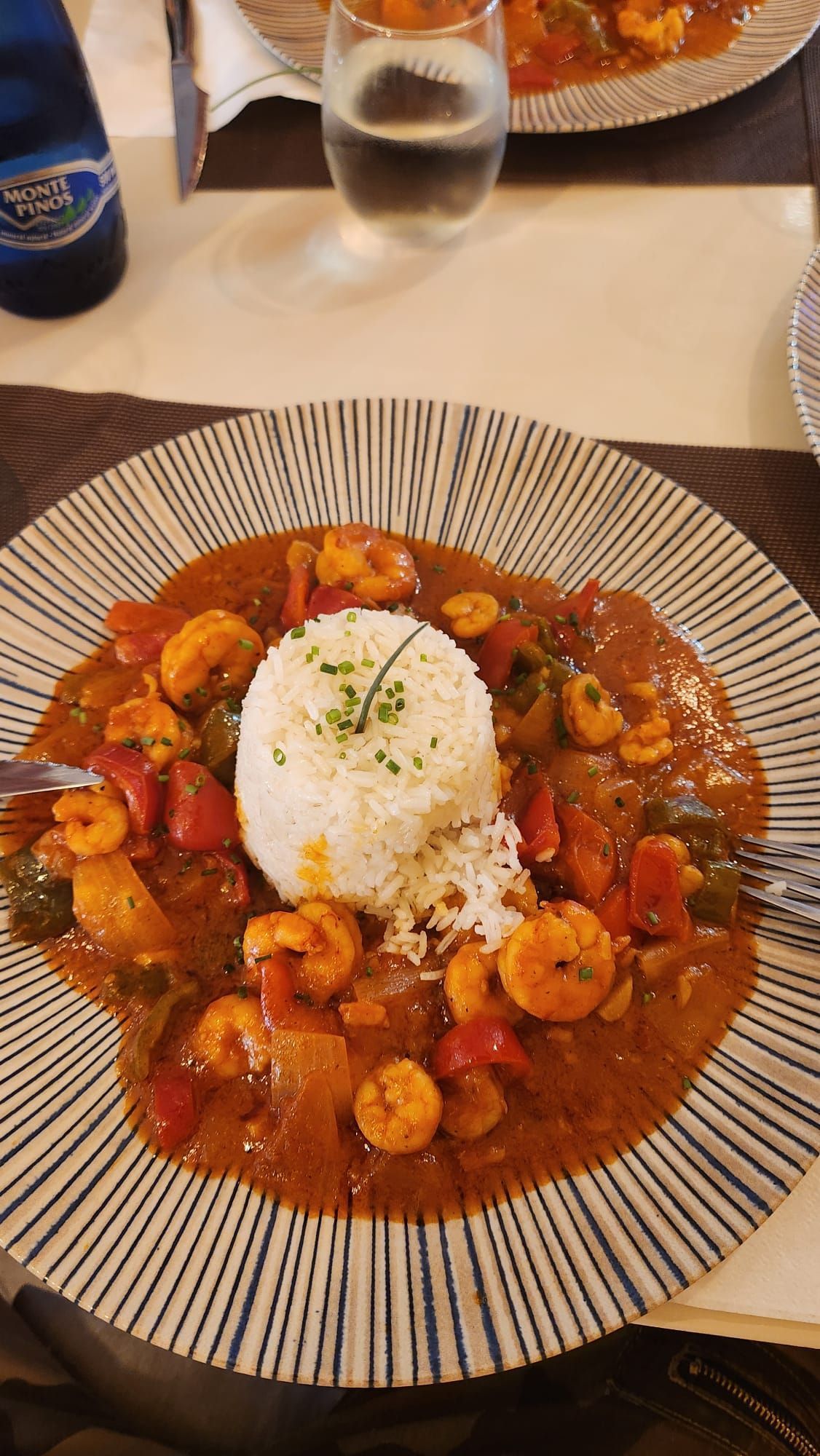 Un plato de comida con camarones y arroz en una mesa.