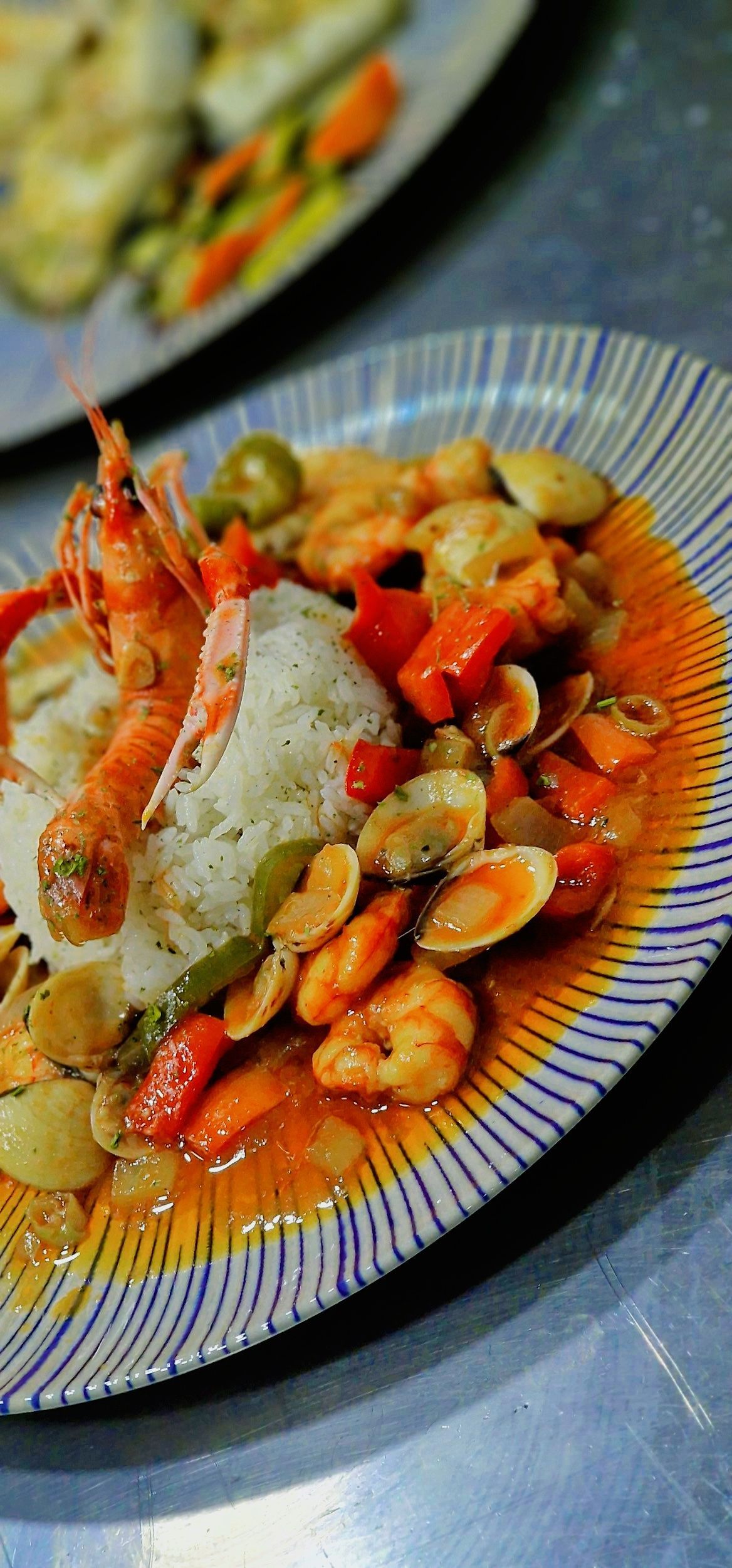 Un primer plano de un plato de comida con camarones y arroz en una mesa.