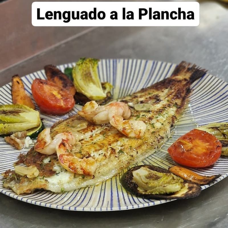 Un plato de lenguado a la plancha con camarones y verduras