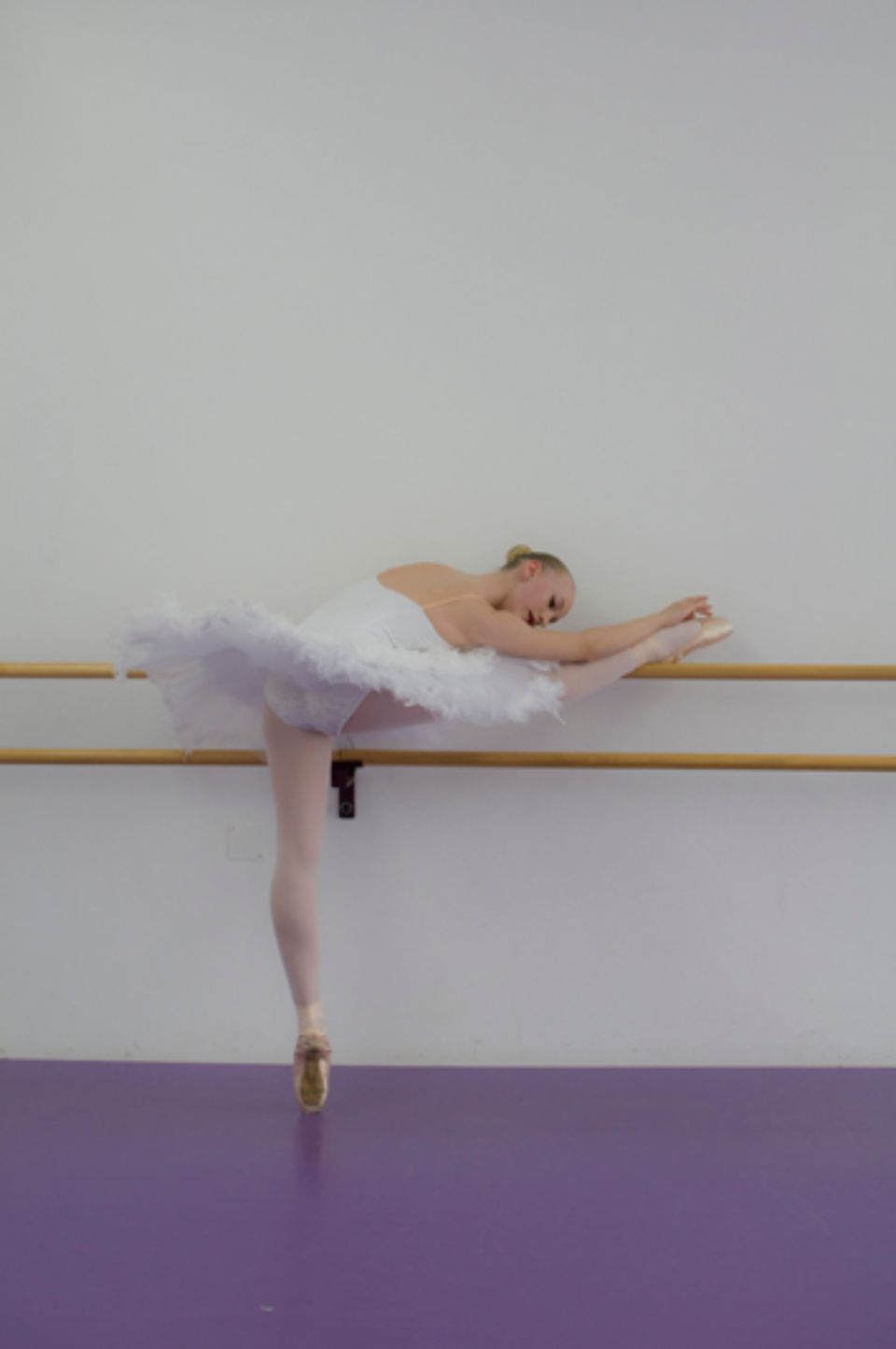 Ballerina dehnt sich an der Ballettstange