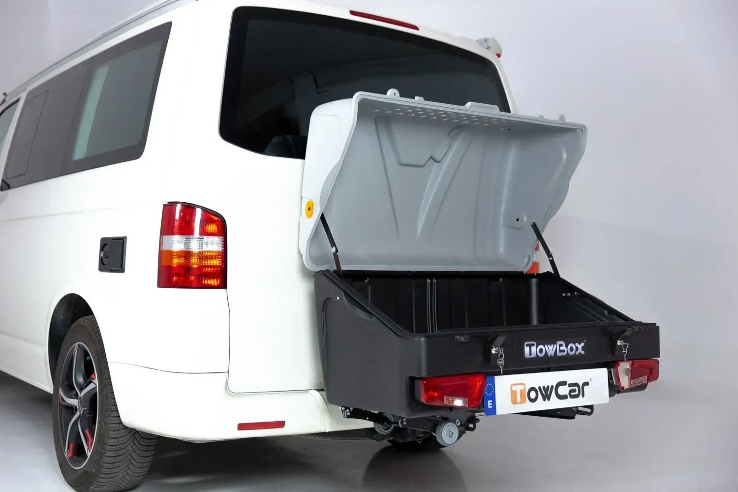 Una furgoneta blanca con una caja de remolque enganchada a la parte trasera.