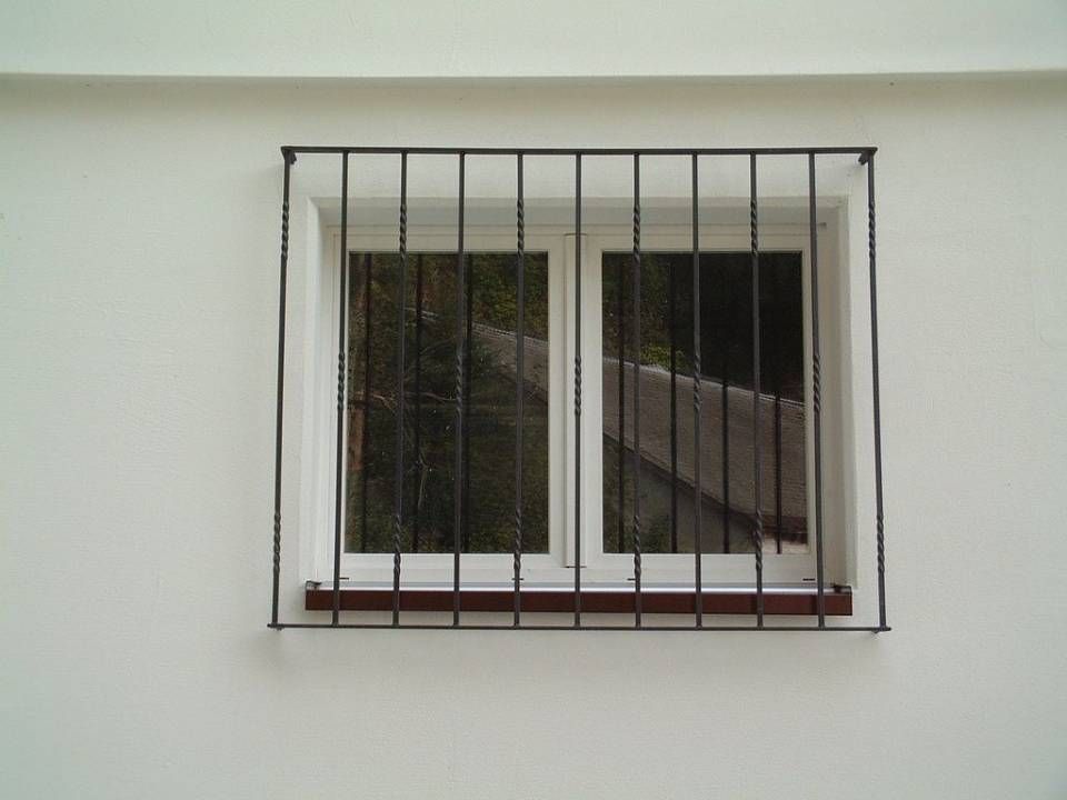 Ein Fenster mit einem schmiedeeisernen Zaun darum. Foto von Stefan Hans Zahner