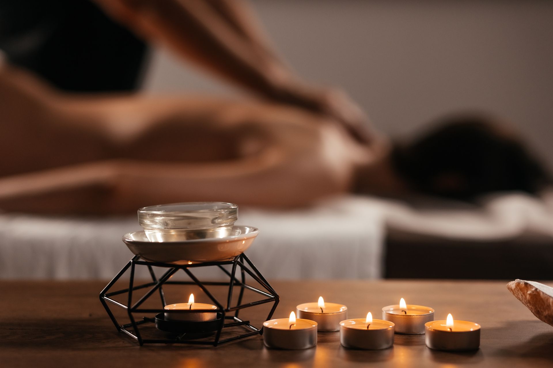 Massage dans une pièce faiblement éclairée avec des bougies sur la table