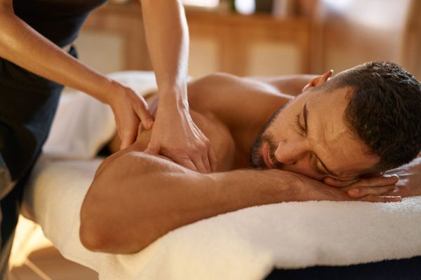 Homme allongé en train de se faire masser l'épaule