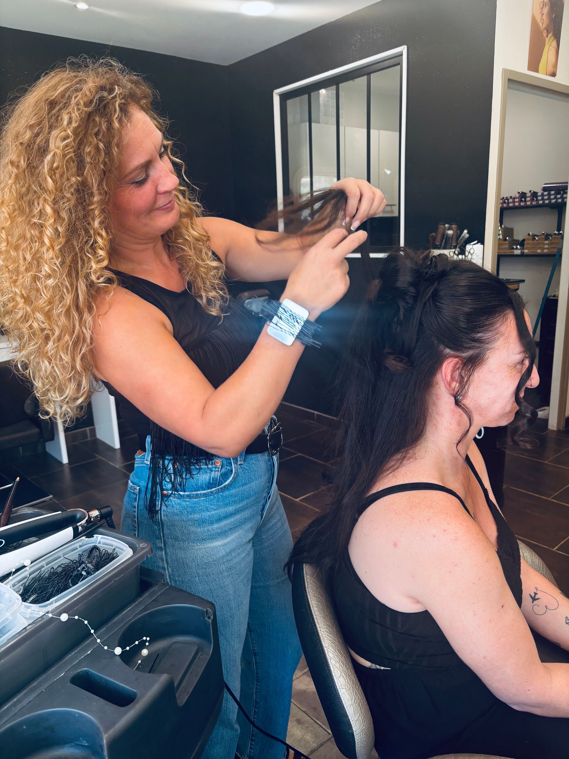 Coiffeur en train d'effectuer une coiffure de mariée à une personne.