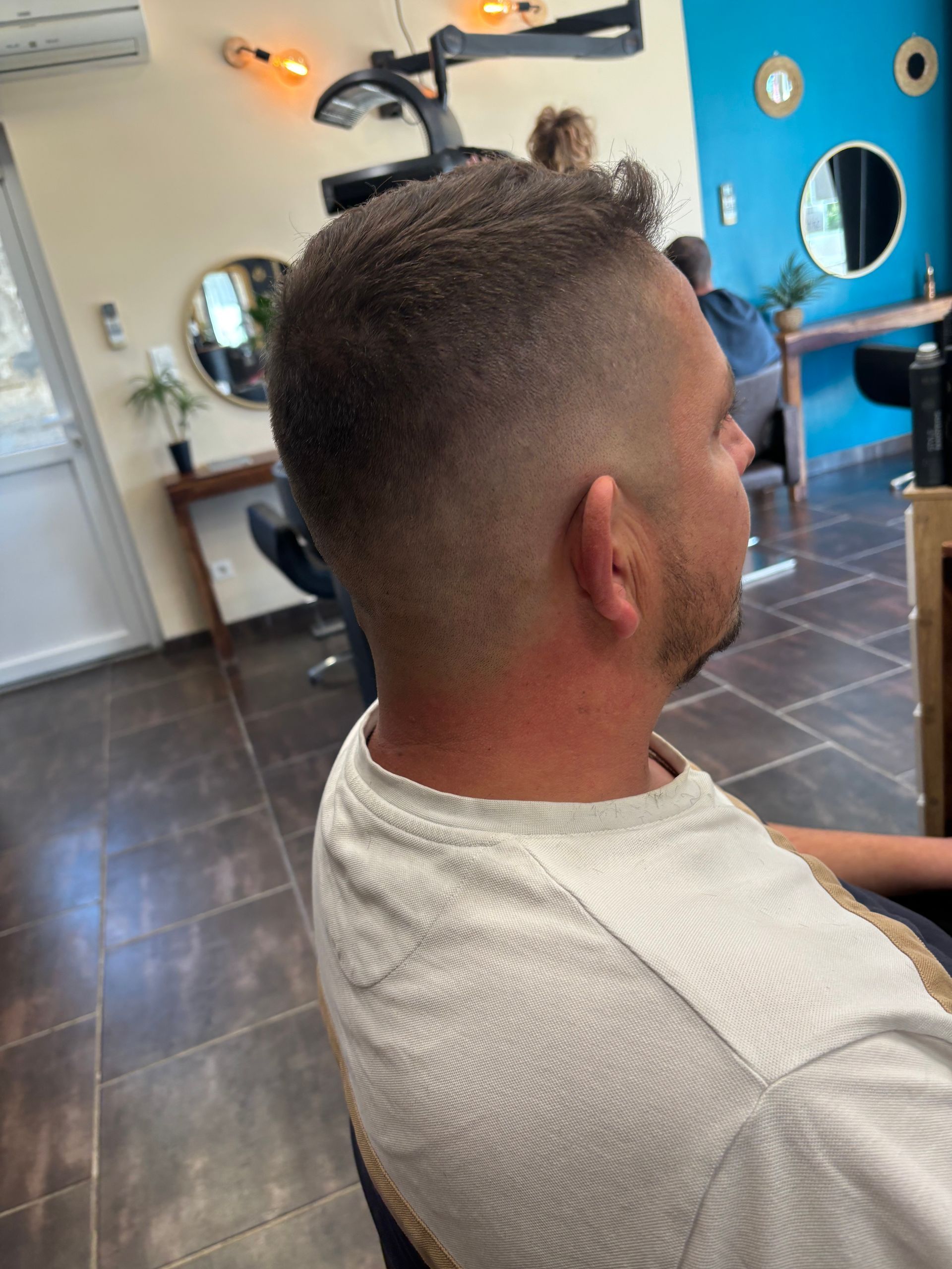 Coupe de cheveux sur homme avec rasage et cheveux courts.