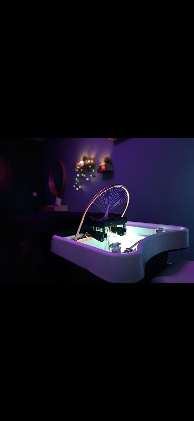 Table noire de spa dans une pièce avec des plantes.