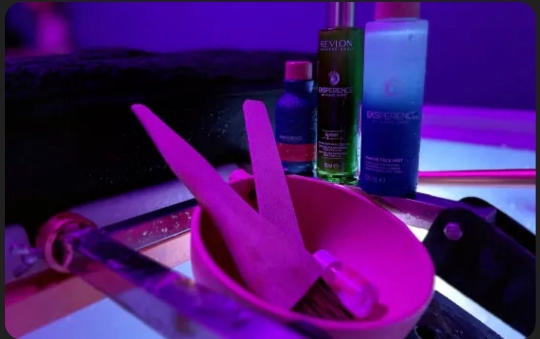 Bol avec pinceaux et produits dans une lumière violette.