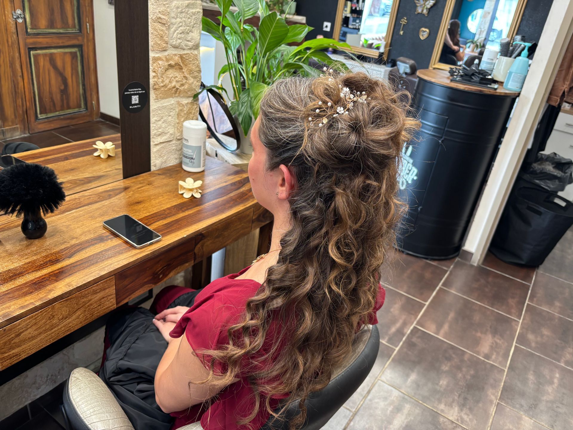 Personne avec une coiffure de mariée assise devant un miroir.