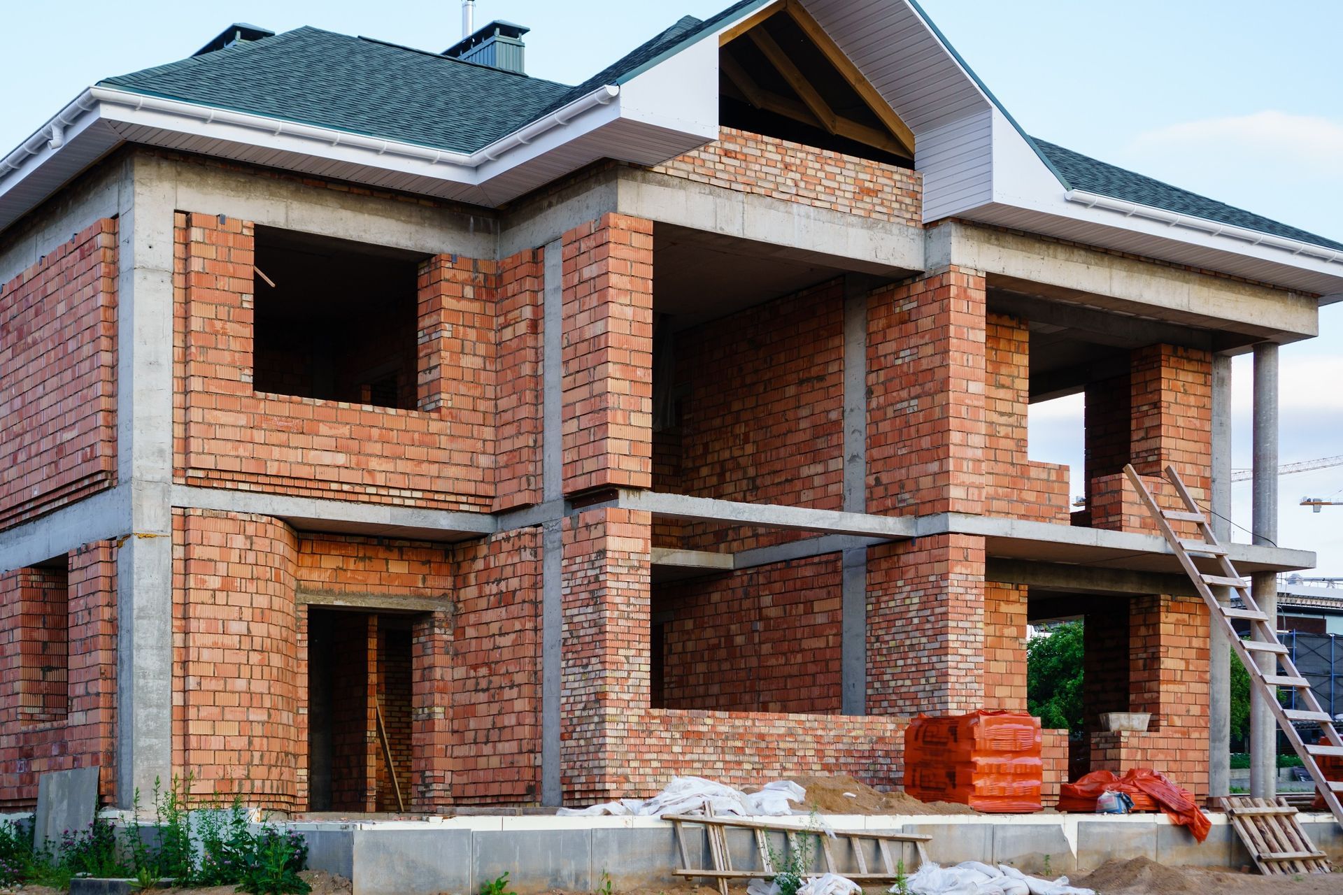 Una gran casa de ladrillo en construcción con techo verde.