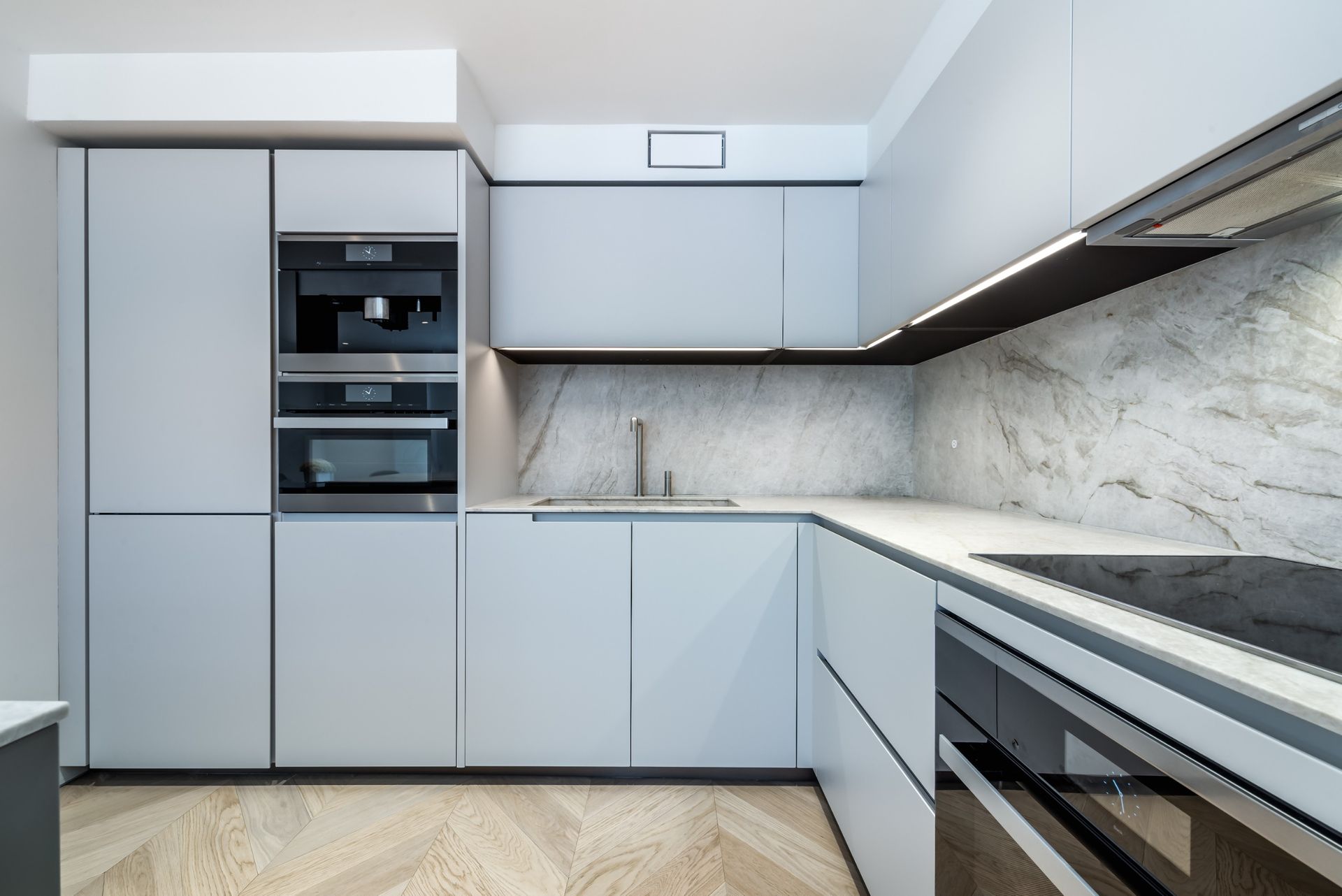 Una cocina con gabinetes blancos y electrodomésticos de acero inoxidable.