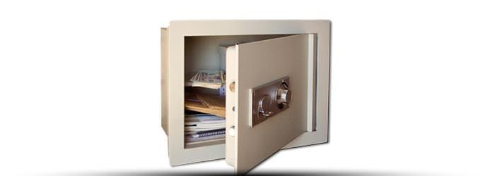 Ouvrez le coffre-fort beige, la porte entrouverte, révélant des étagères et des objets de valeur à l'intérieur.