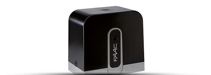 Appareil compact noir à la finition brillante et au panneau avant ovale argenté vertical, présenté sur fond blanc.