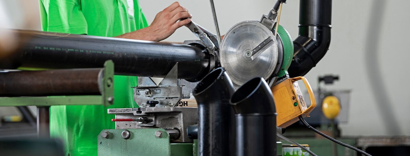 Eine Person arbeitet in einer Fabrik an einer Maschine.