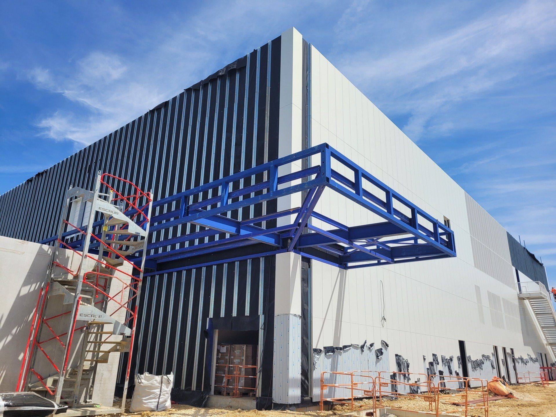 Structure métallique bleue autour d'un bâtiment industriel