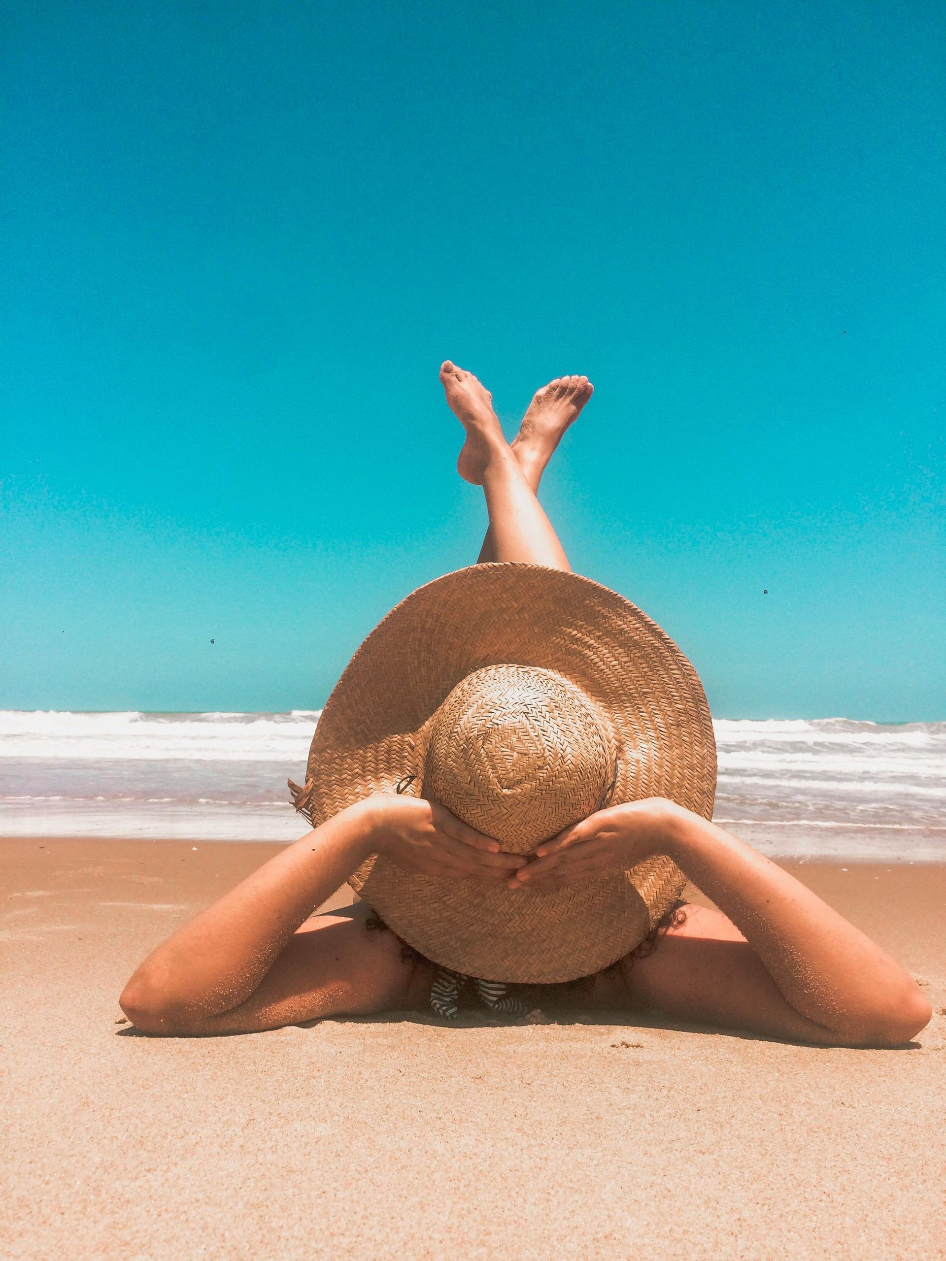 Person genießt Strand und Sonne als Symbol für Urlaubsanspruch und gesetzliche Urlaubstage.