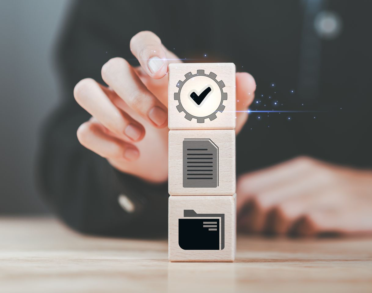 Empilement manuel de blocs de bois ornés d'icônes : coche, document, dossier.