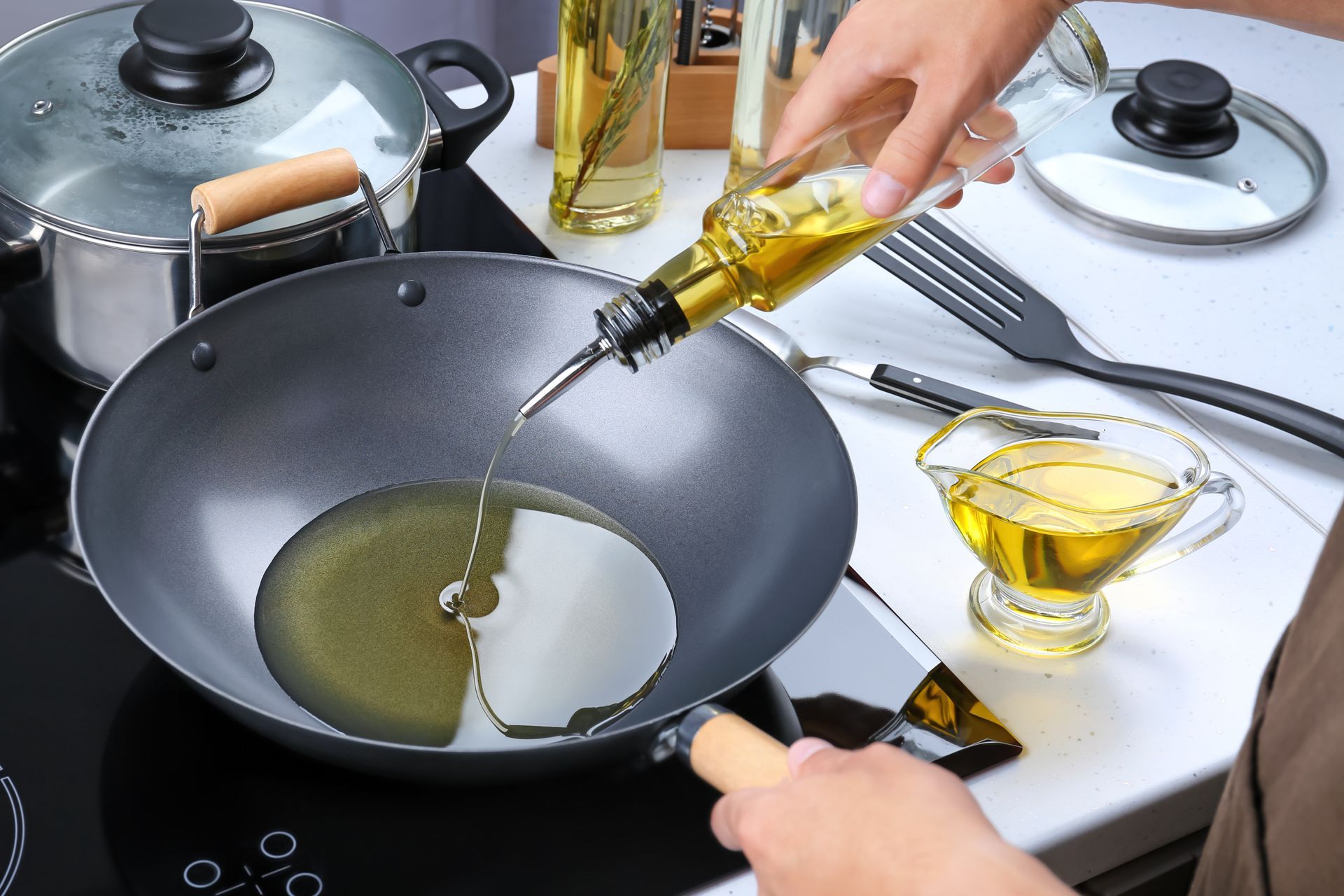 Une personne versant de l'huile dans une casseroles