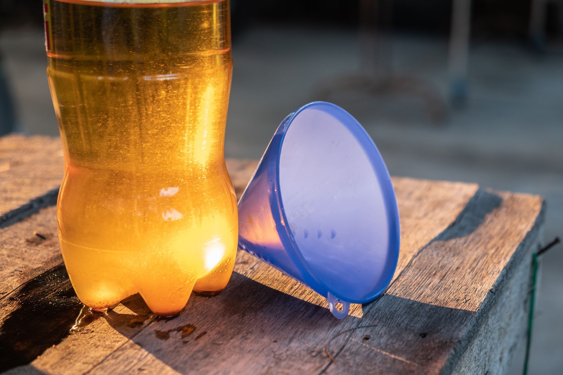 Une bouteille plastique avec de l'huile usagée et un entonnoir