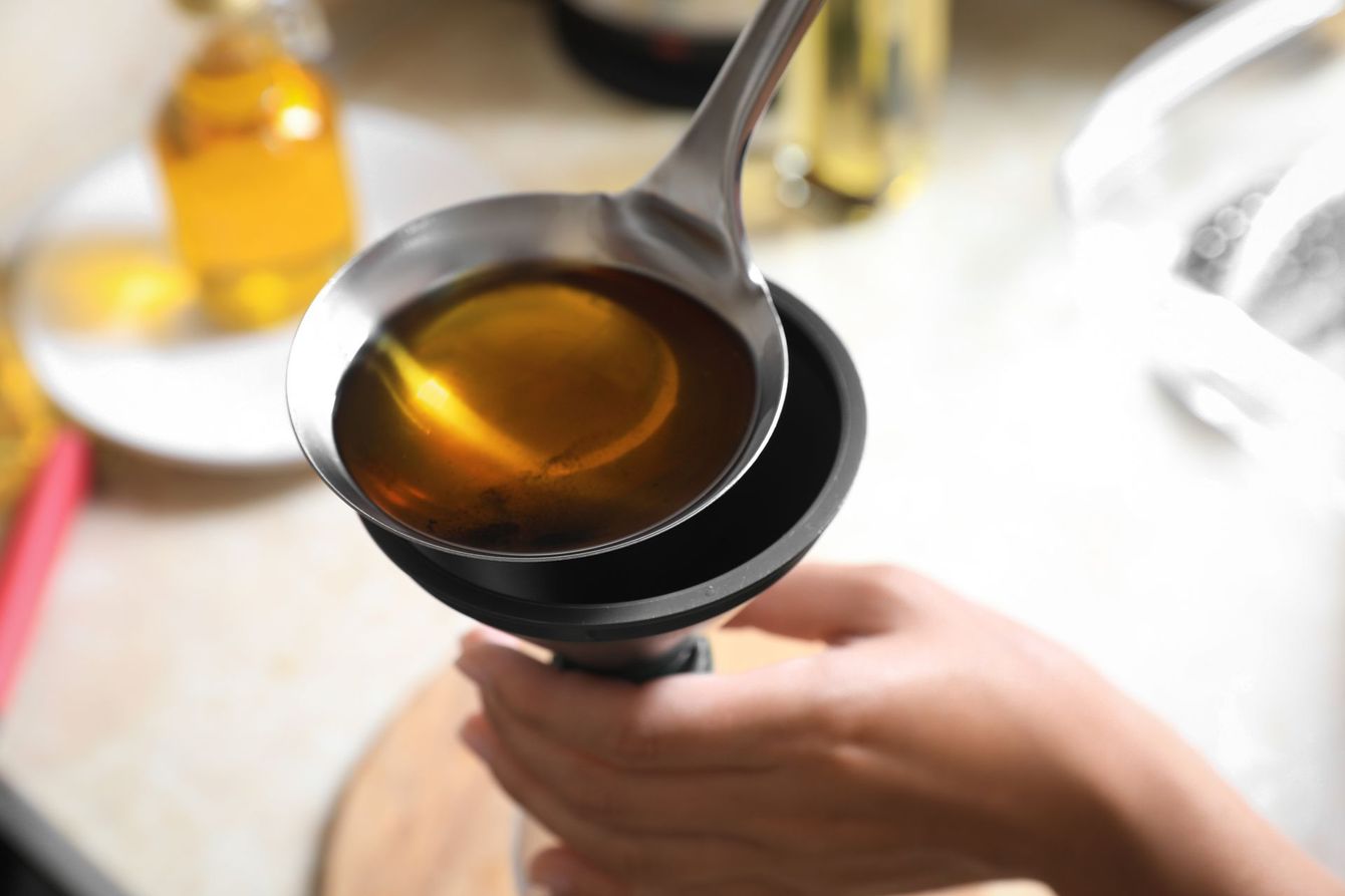 Une personne versant de l'huile dans une bouteille