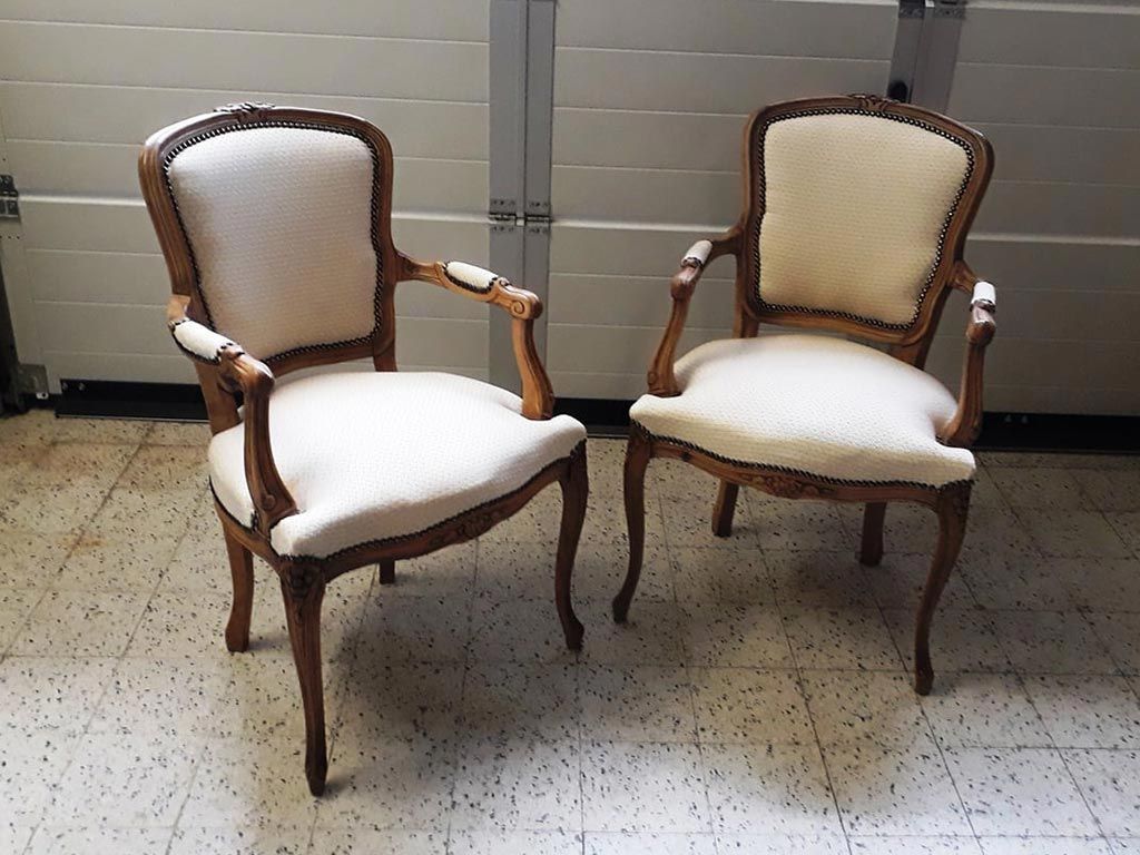 Vieilles chaises en bois avec accoudoir et rembourrage en tissus blanc