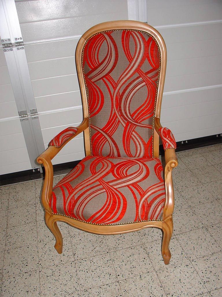 Vieux fauteuil année 70 rembourré en tissus avec formes abstraites orange et accoudoirs en bois