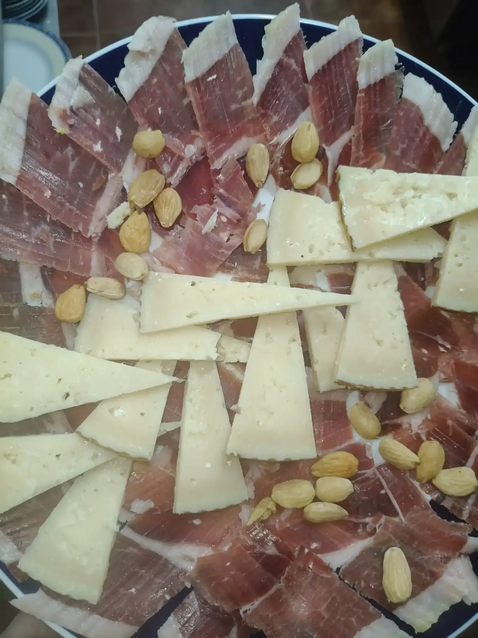 Plato de jamón lonchas, queso y almendras.