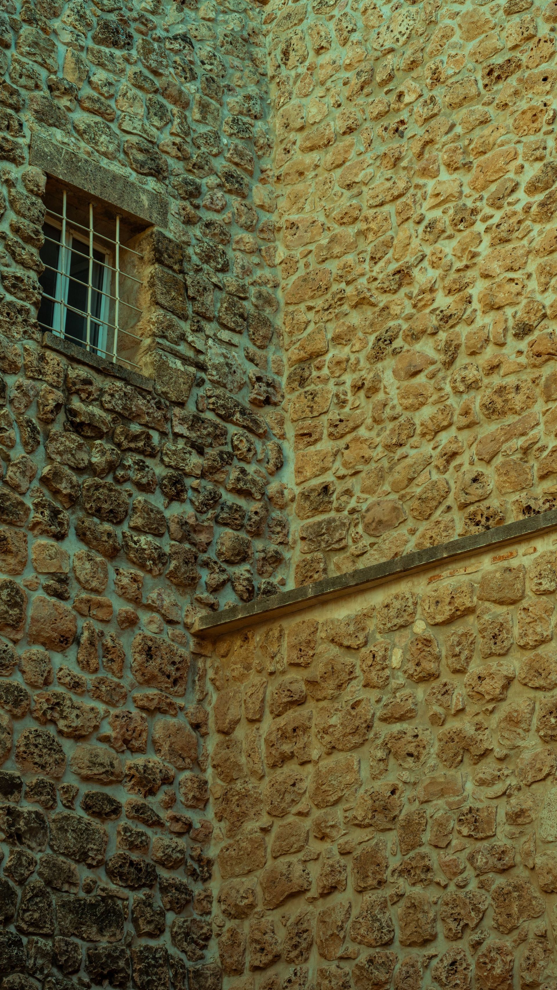 Coin d'un bâtiment en pierre aux murs rugueux