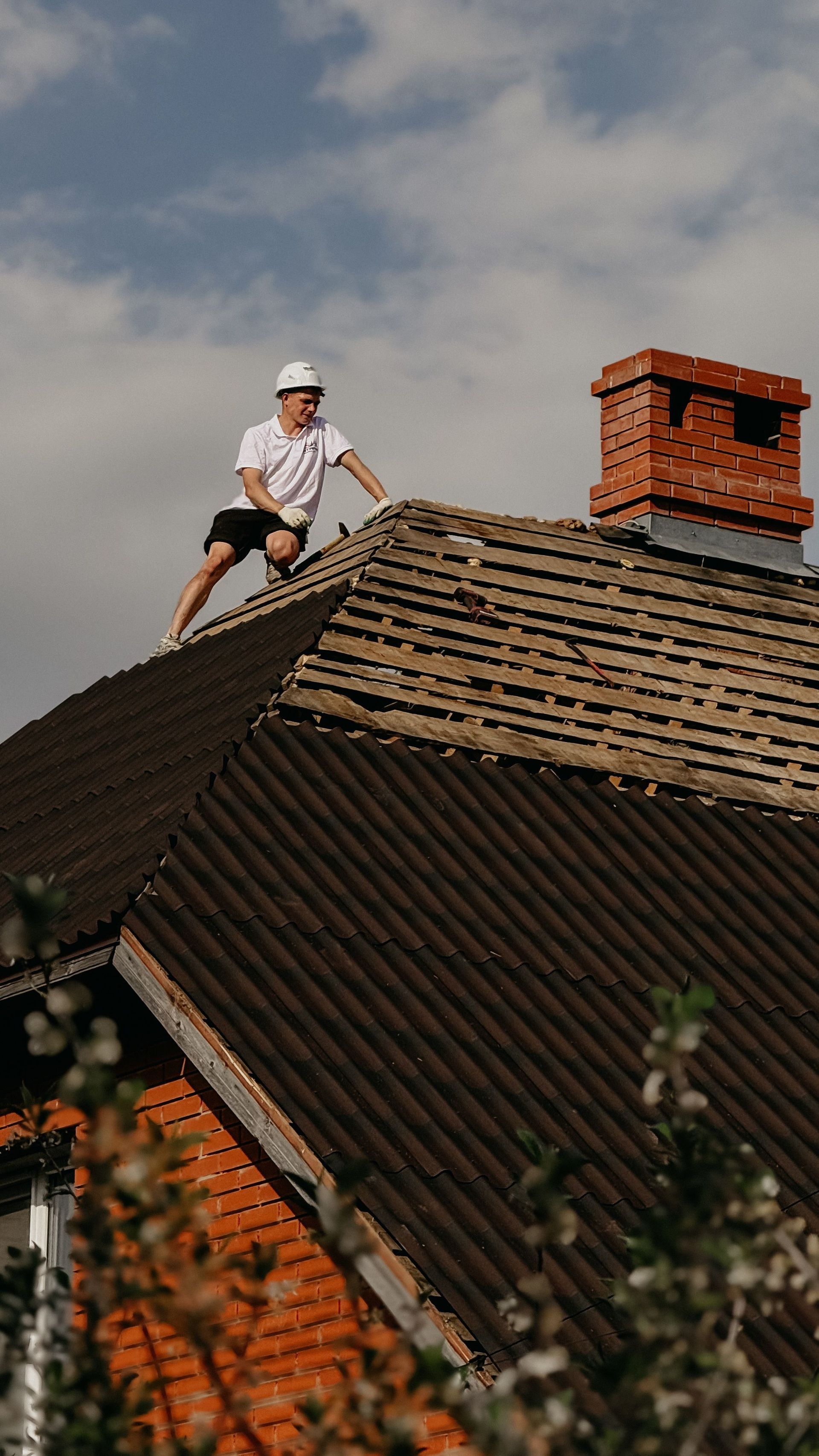 Ouvrier sur un toit près d'une cheminée en briques