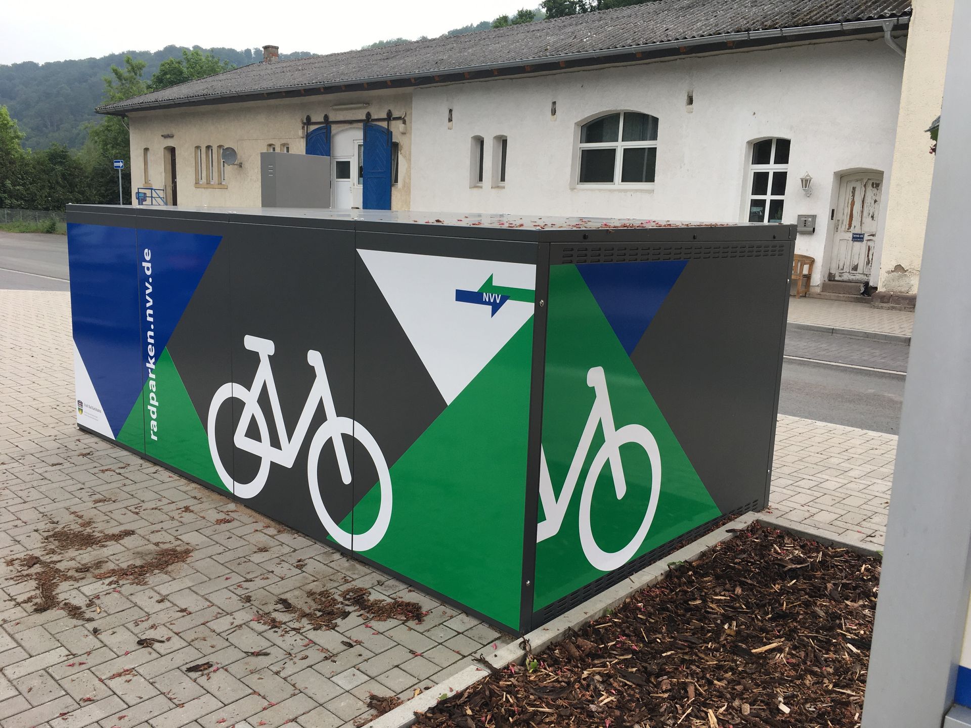 Eine blau-grün-weiße Kiste mit darauf gemalten Fahrrädern