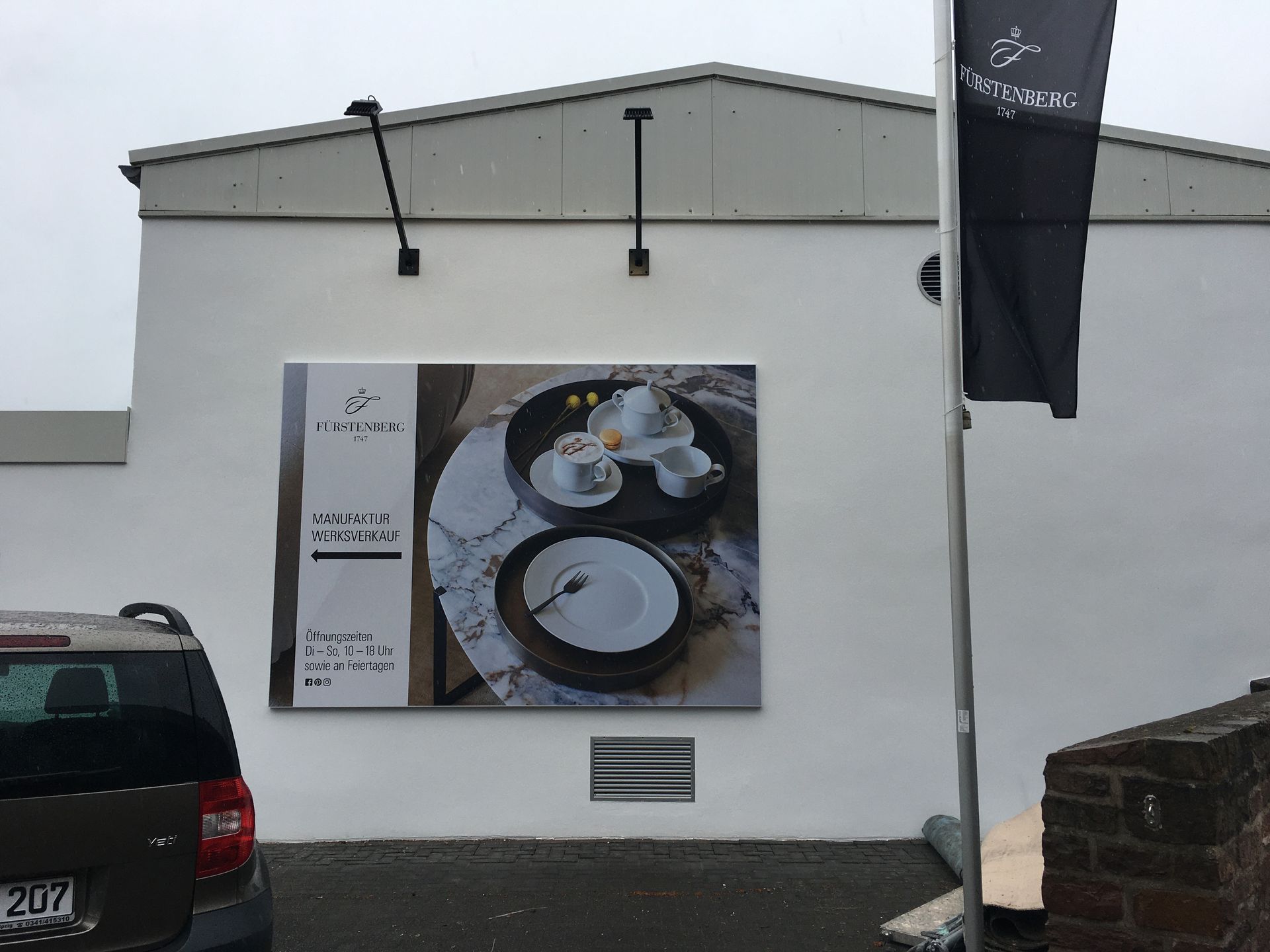 Eine weiße Wand mit einem Bild von Tellern und Tassen darauf