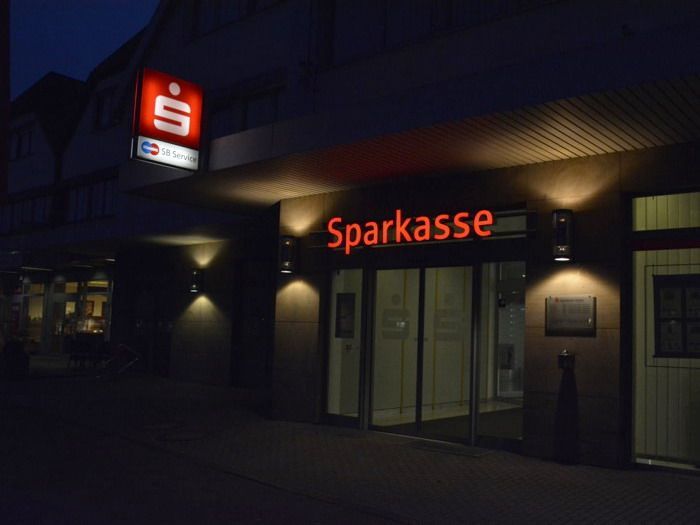 Eine Sparkasse ist nachts beleuchtet