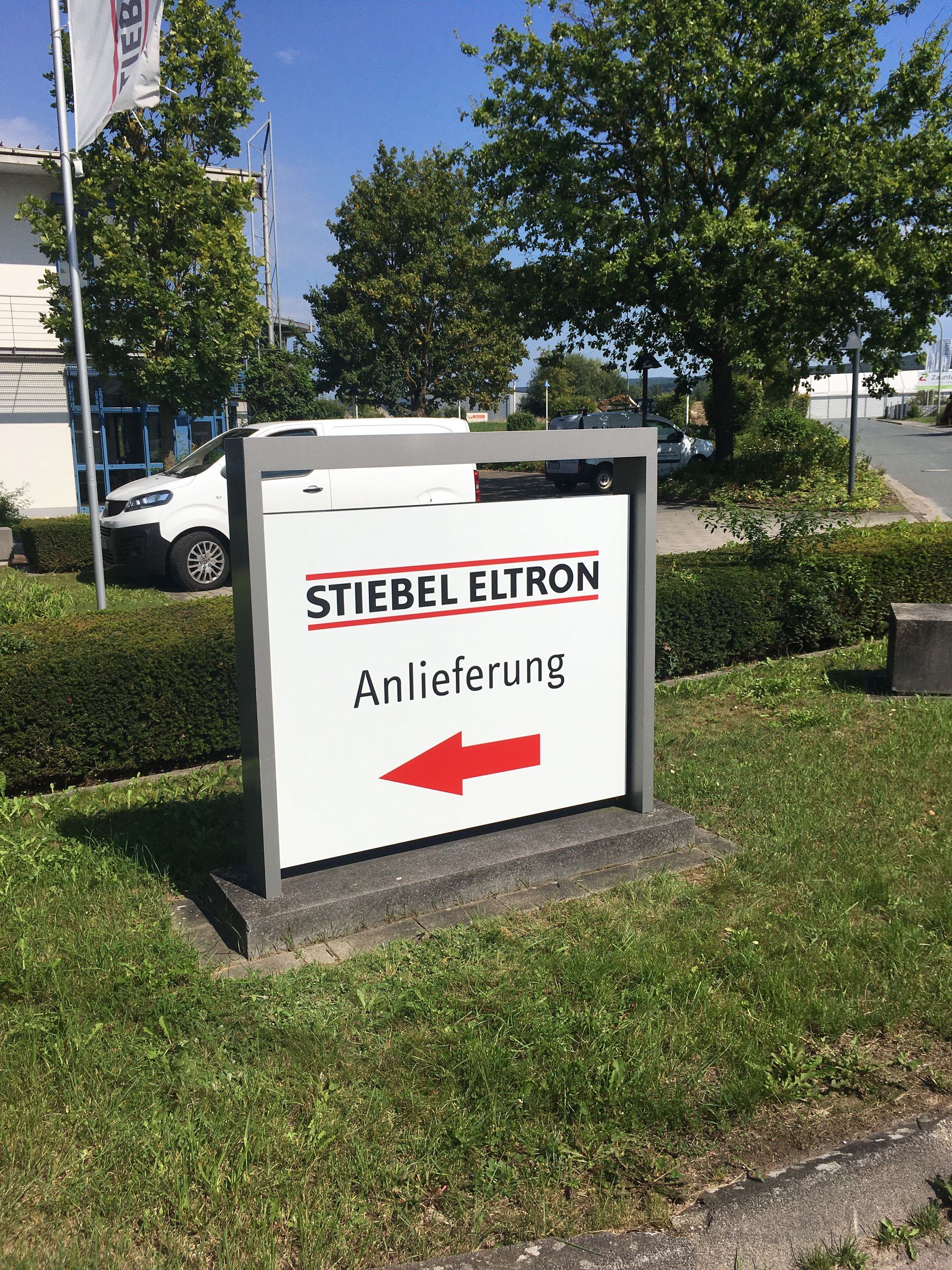 Ein weißes Schild mit einem roten Pfeil, der nach rechts zeigt.