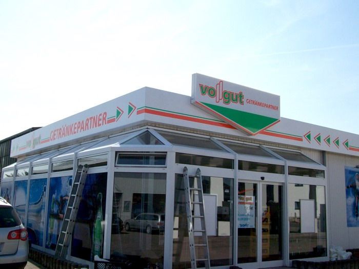 Ein weißes Gebäude mit einem grünen Schild mit der Aufschrift