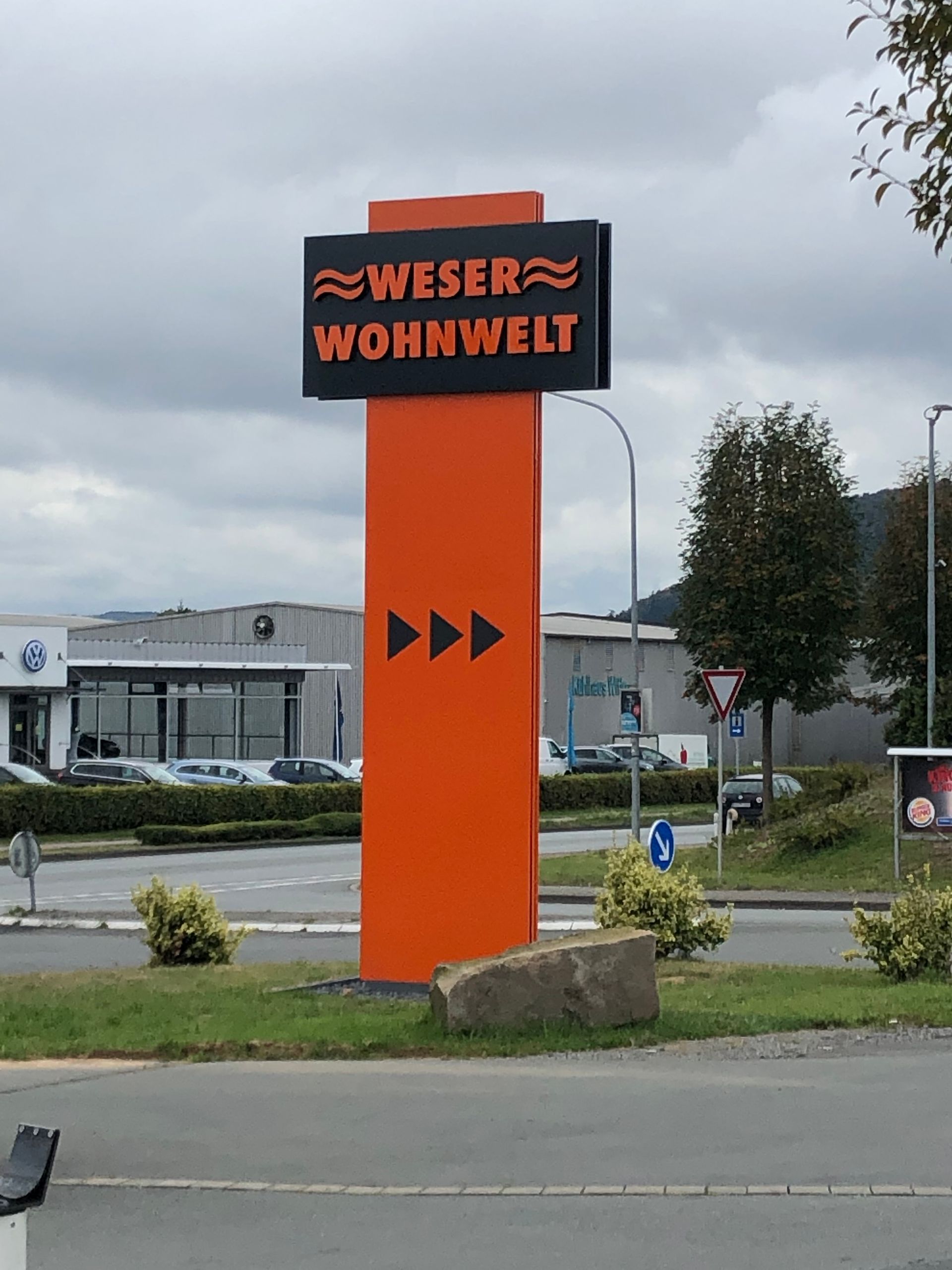 Ein orange-schwarzes Schild mit der Aufschrift „Weser Wohnwelt“