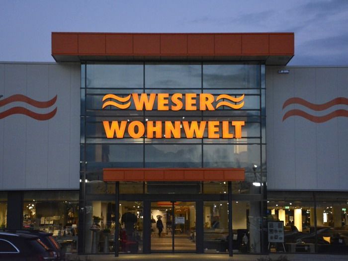 Die Fassade eines Weser Wohnwelt-Geschäfts bei Nacht