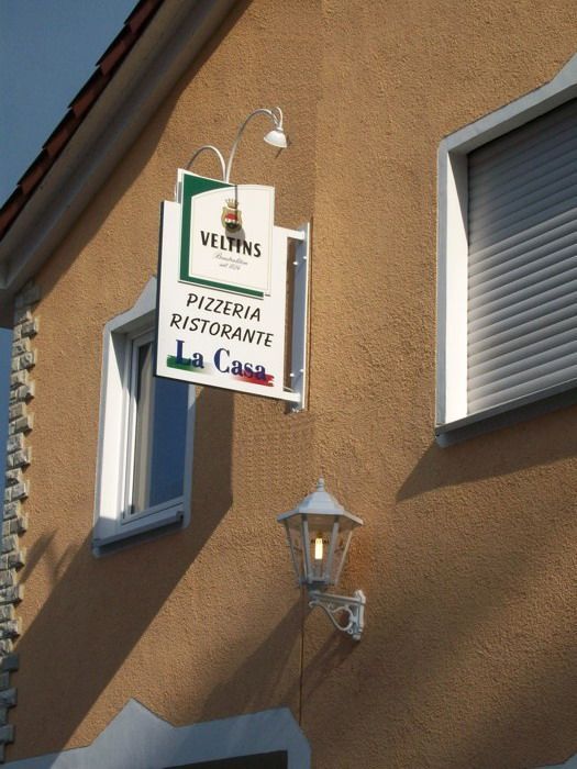 Ein Pizzeria-Schild hängt an der Seite eines Gebäudes