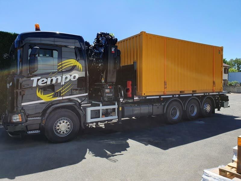 Camion poids lourd avec bras grue qui transporte un contenaire