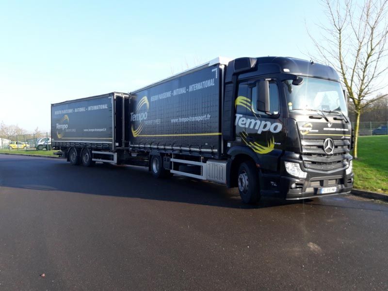 Un porteur super lourd avec deux remorques sur un parking