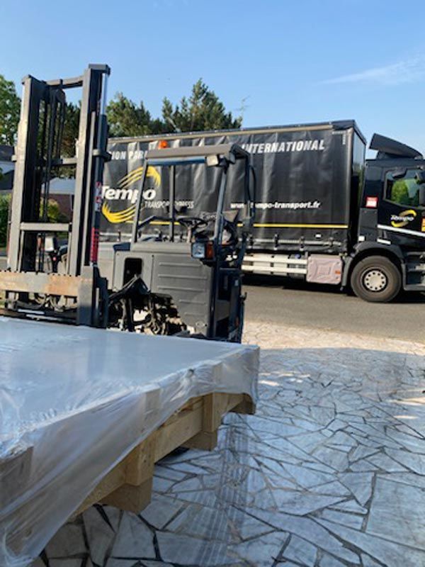 Livraison d'un gros colis en palette chez un particulier sous un autre angle