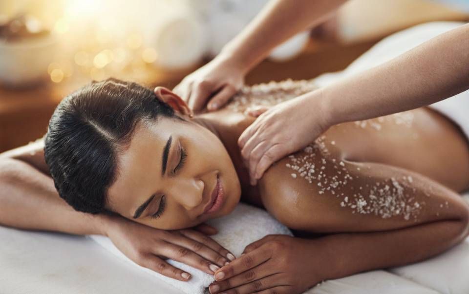 Personne recevant un massage du dos à l'huile sur une table de spa