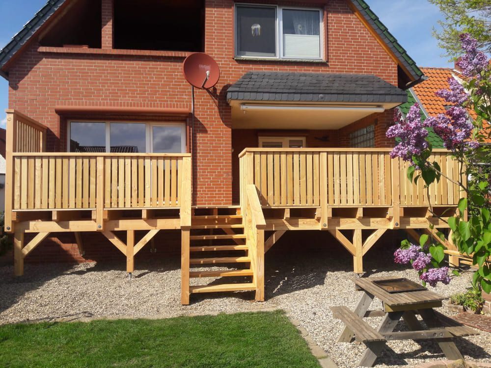 Ein Backsteinhaus mit Holzterrasse und Treppe