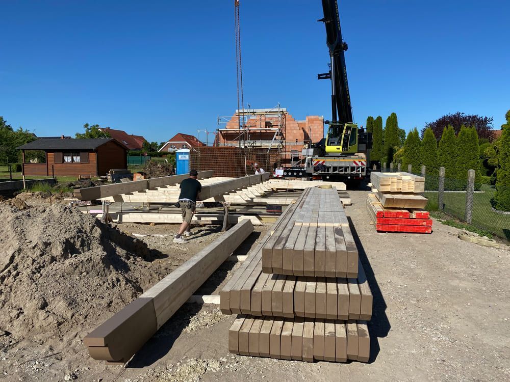 Ein Kran hebt einen Stapel Ziegelsteine auf einer Baustelle an