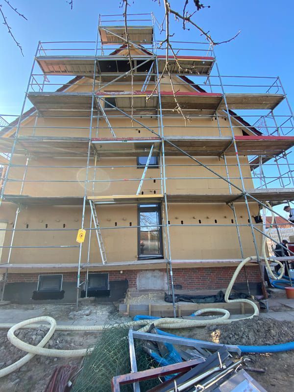 Es wird ein Haus gebaut, das von einem Gerüst umgeben ist.