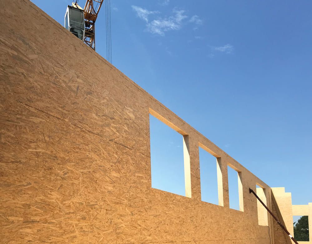 Ein im Bau befindliches Gebäude mit einem Kran im Hintergrund.