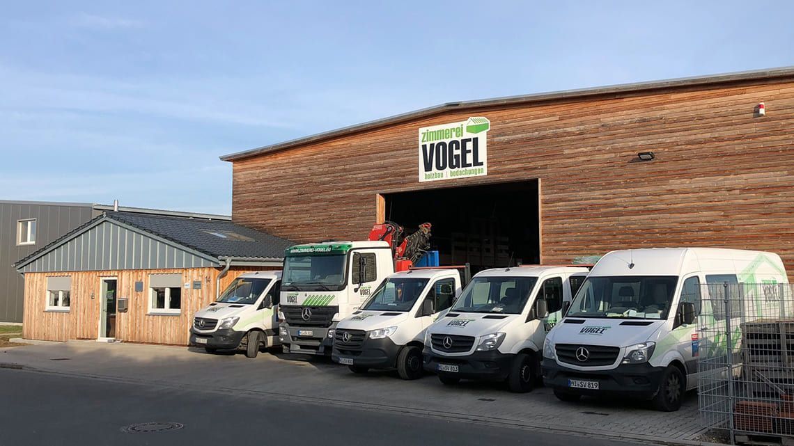 Eine Reihe von Lieferwagen parkt vor einem Gebäude.